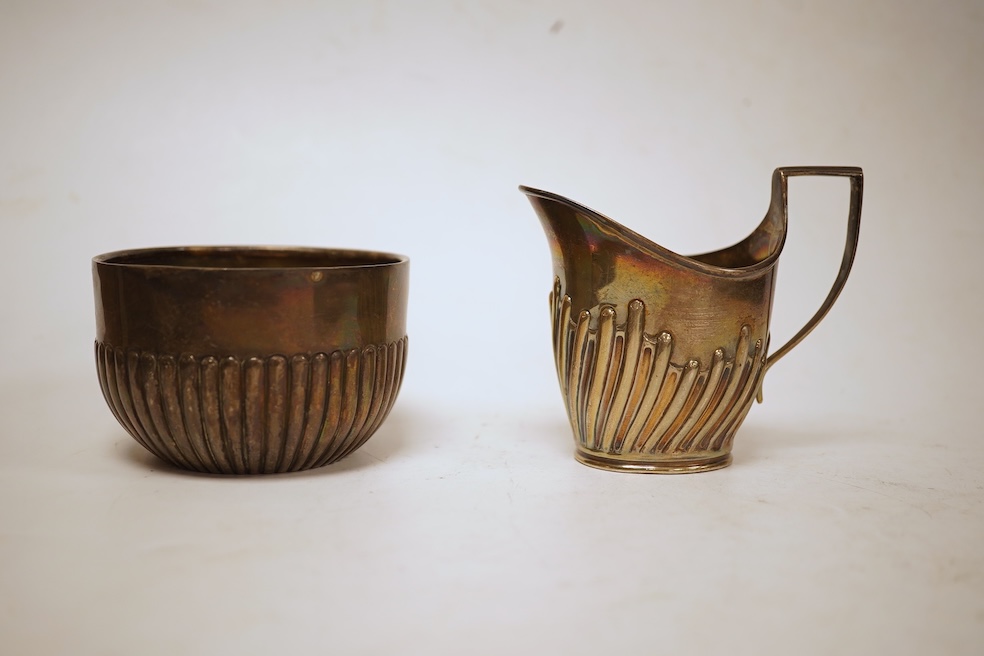 A late Victorian demi-fluted cream jug and sugar bowl, Charles Stuart Harris, London, 1888, together with cased silver christening egg cup, spoon and napkin ring and two other silver napkin rings.